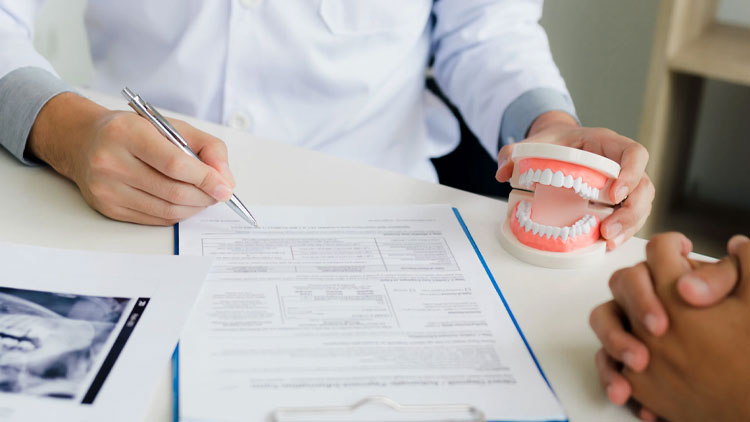 Dentist reviewing CDCP covers root canals criteria with patient