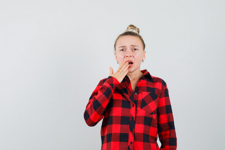 a woman looking worried about the dental numbing after a dental treatment that hasn't faded yet. 