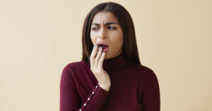 a woman touching her cheek worried about the dental numbing after a dental treatment.