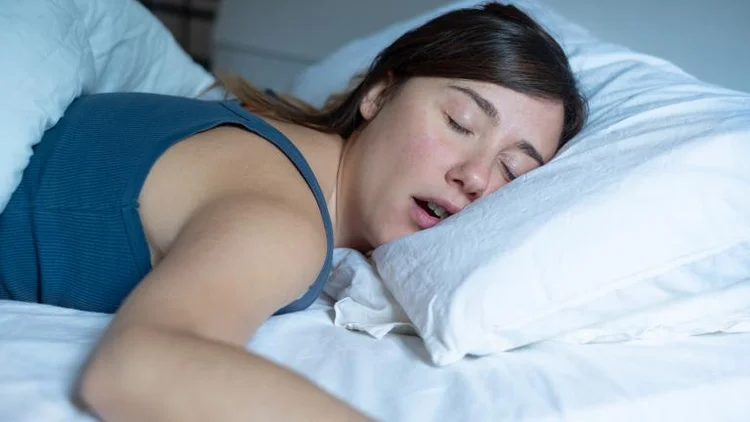 A picture of a woman who is snoring while sleeping