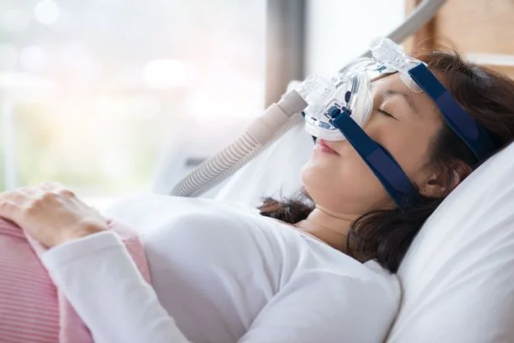 A picture of a woman sleeping with sleep apnea device